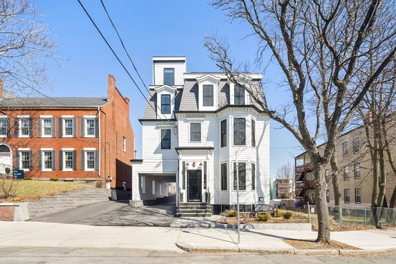 Front view of a three-story house with bay windows and a central entrance.