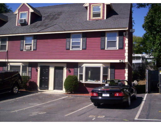 Front view of a two-story house with an attic and parking area.