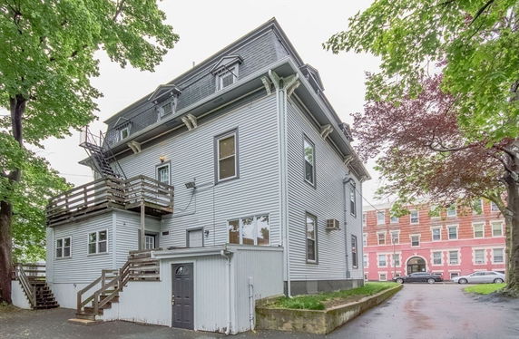Front view of a multi-story house with exterior stairs and a small balcony.