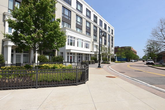 Front view of a multi-story building with large windows and a landscaped area.