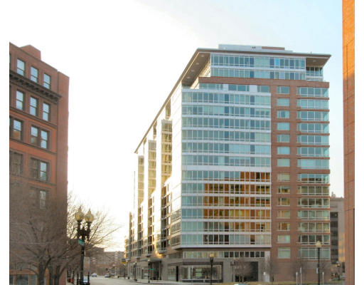 Front view of a multi-story modern building with large glass windows.