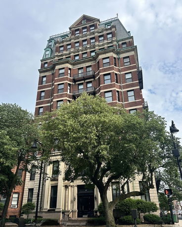 Front view of a multi-story brick building with decorative architectural features.