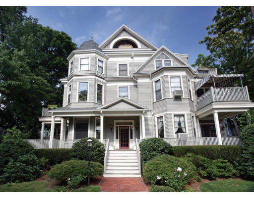 Front view of a multi-story Victorian house with a wrap-around porch.