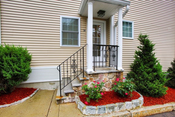 Front view of a house entrance with steps and a small porch.