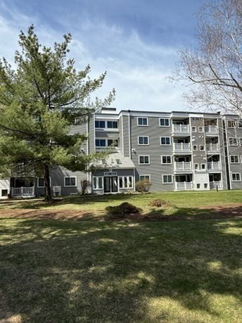 Front view of a multi-story apartment building with balconies.