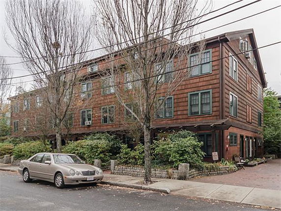 Front view of a multi-story residential building with brick façade and numerous windows.