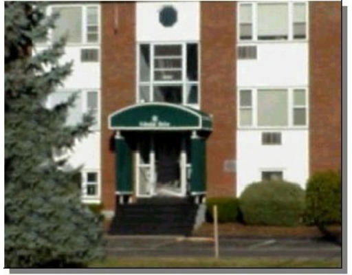 Front view of a multi-story building with a central entrance and windows.
