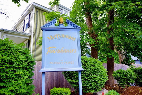 Front view of a townhouse with a sign for Merrymount Townhouses.