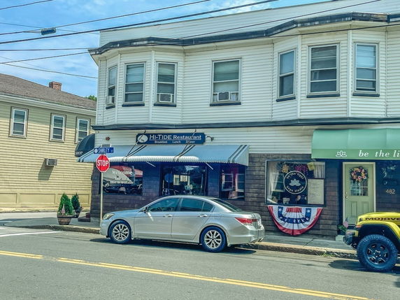 Front view of a two-story building with a restaurant and another shop on the ground floor.