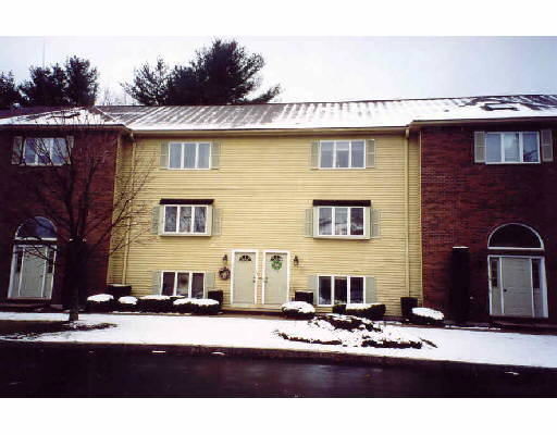 Front view of a three-story residential building with a combination of brick and siding.