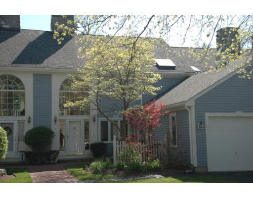 Front view of a two-story house with arched windows and a single garage.