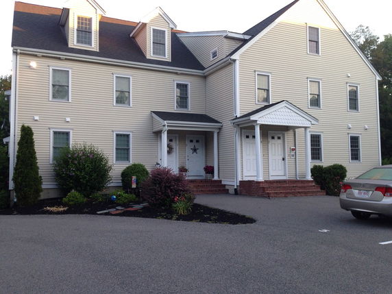 Front view of a multi-story house with dual entrances and dormer windows.
