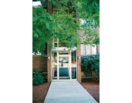 Front view of a building entrance with glass doors and brick exterior.