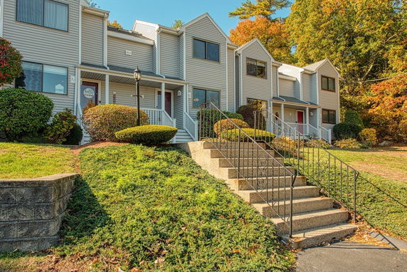 Front view of a two-story townhouse with a central staircase leading to the entrance.