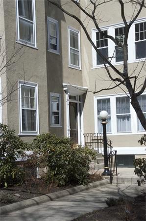 Front view of a multi-story building with numerous windows and a small entrance.