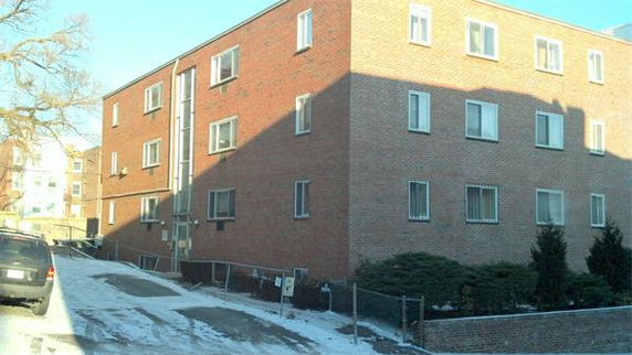 Front view of a three-story brick apartment building.