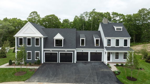Front view of a two-story house with multiple gables and a triple garage.