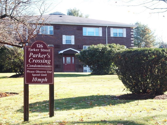 Front view of a brick condominium building with a two-story structure.