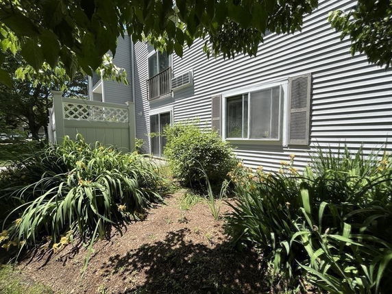 Side view of a multi-story building with a garden area.