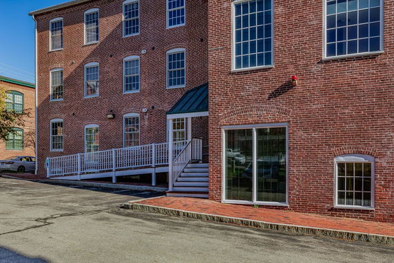 Front view of a brick building with multiple large windows.