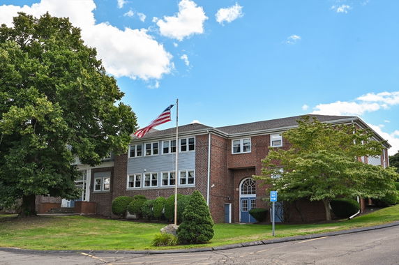 Front view of a two-story brick building with multiple windows.
