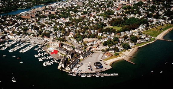 Aerial view of a coastal town with marina and residential area.