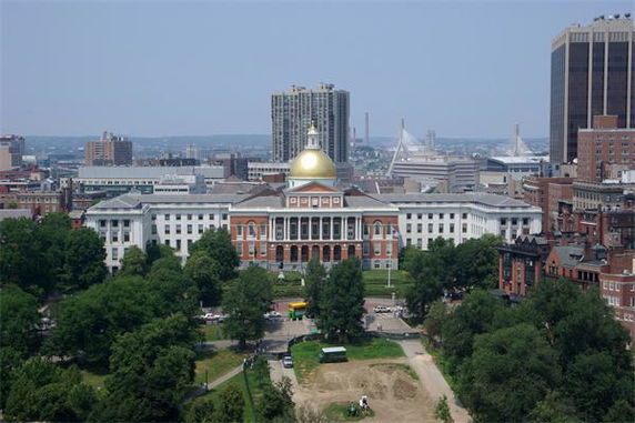 Front view of a large historical building with a golden dome and multiple columns.