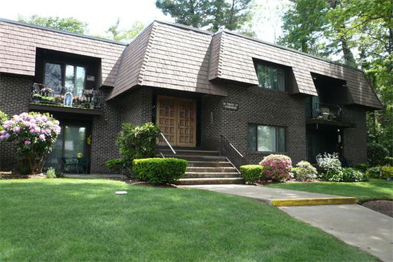Front view of a two-story brick apartment building with balconies.
