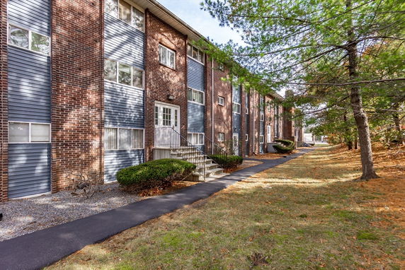 Front view of a multi-story brick building with multiple entrances.