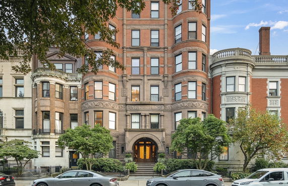 Front view of a multi-story brick building with ornate architectural details.
