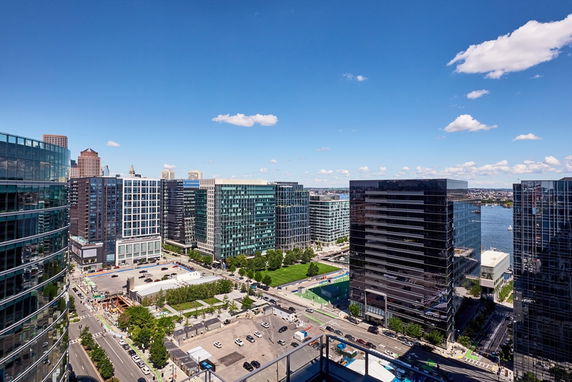 Panoramic view of a cityscape with modern buildings and a river in the background.
