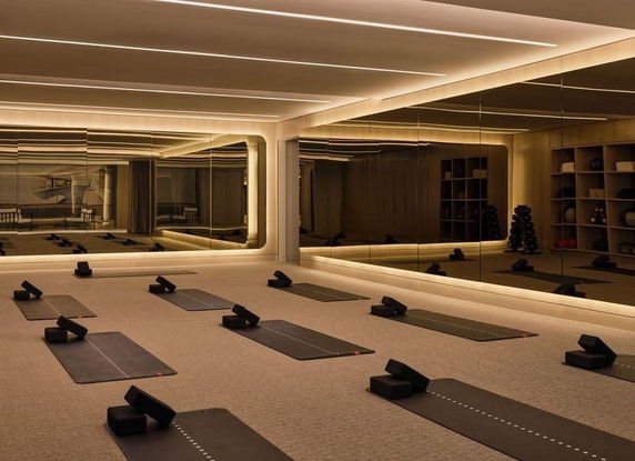 Interior view of a yoga or fitness room with exercise mats and mirrors.