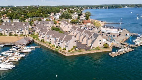 Panoramic view of waterfront residential complex with marina.