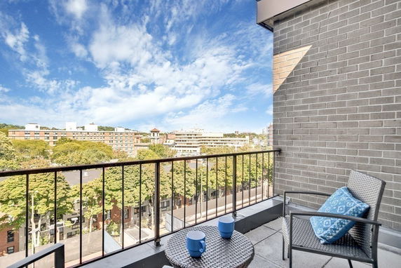 Panoramic view of surrounding buildings and trees from a balcony.