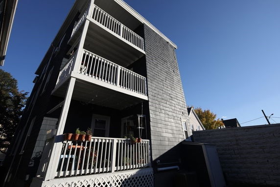 Side view of a multi-story residential building with balconies.