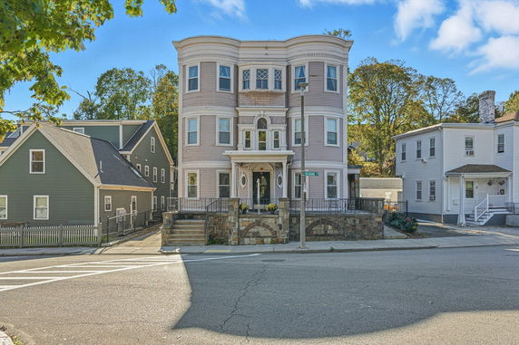 Front view of a three-story house with decorative architecture and stone accents.