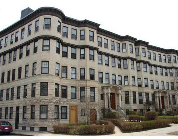 Front view of a multi-story residential building with a classic design and multiple windows.