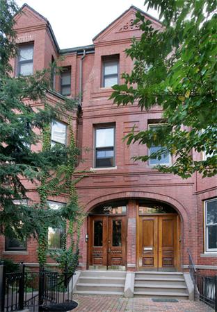 Front view of a three-story brick building with arched entrances.