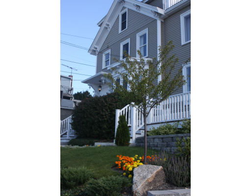 Front view of a two-story house with a porch and white railings.