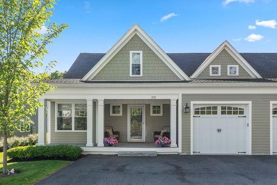 Front view of a house with a porch and a two-car garage.