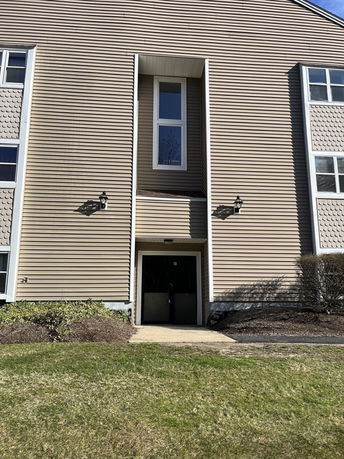 Front view of a building with a central entrance and vertical windows.