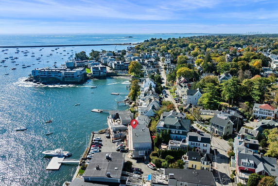 Aerial view of a coastal town with houses and buildings near the waterfront.
