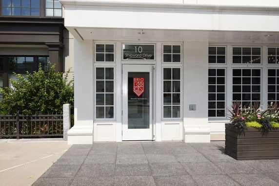 Front view of a building entrance with a glass door and multiple windows.