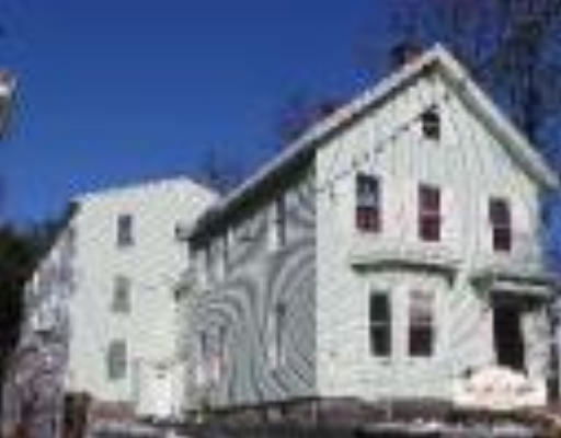 Front view of a multi-story house with a gable roof.
