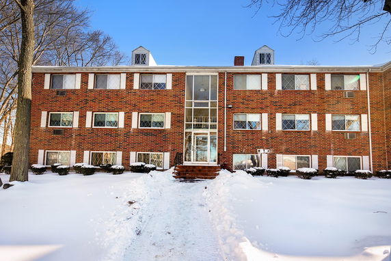 Front view of a three-story brick building with a central glass entrance.