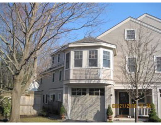 Front view of a multi-story house with an attached garage and a bay window.