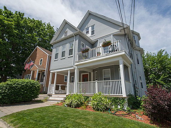 Front view of a two-story house with a porch and balcony.