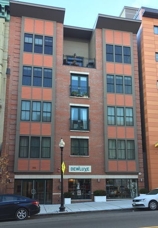 Front view of a multi-story brick building with modern design elements.