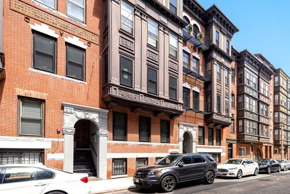 Front view of a multi-story brick building with decorative window frames.