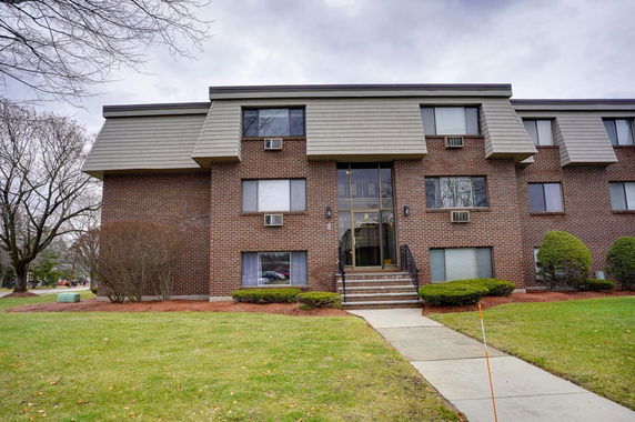 Front view of a multi-story brick apartment building.